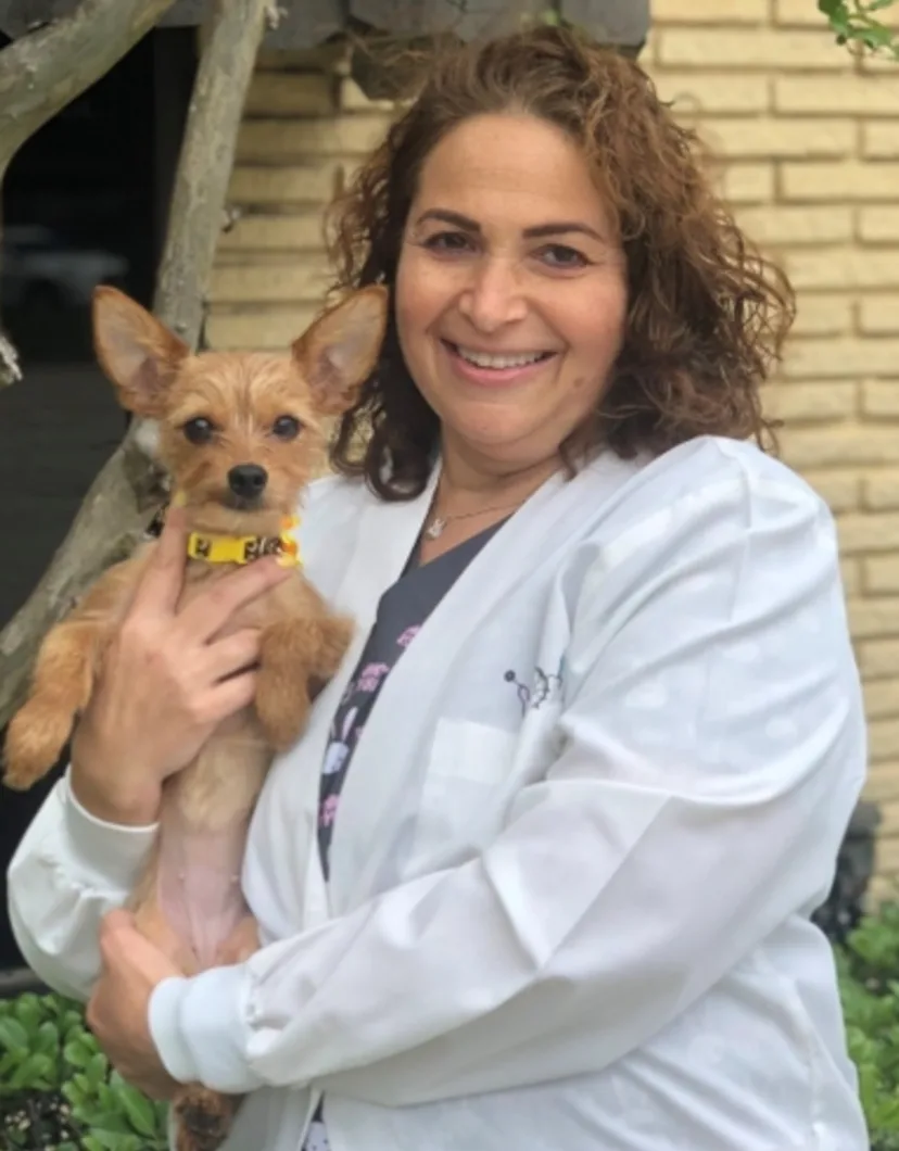 Portrait of Dr. Tami Lass holding a small brown dog